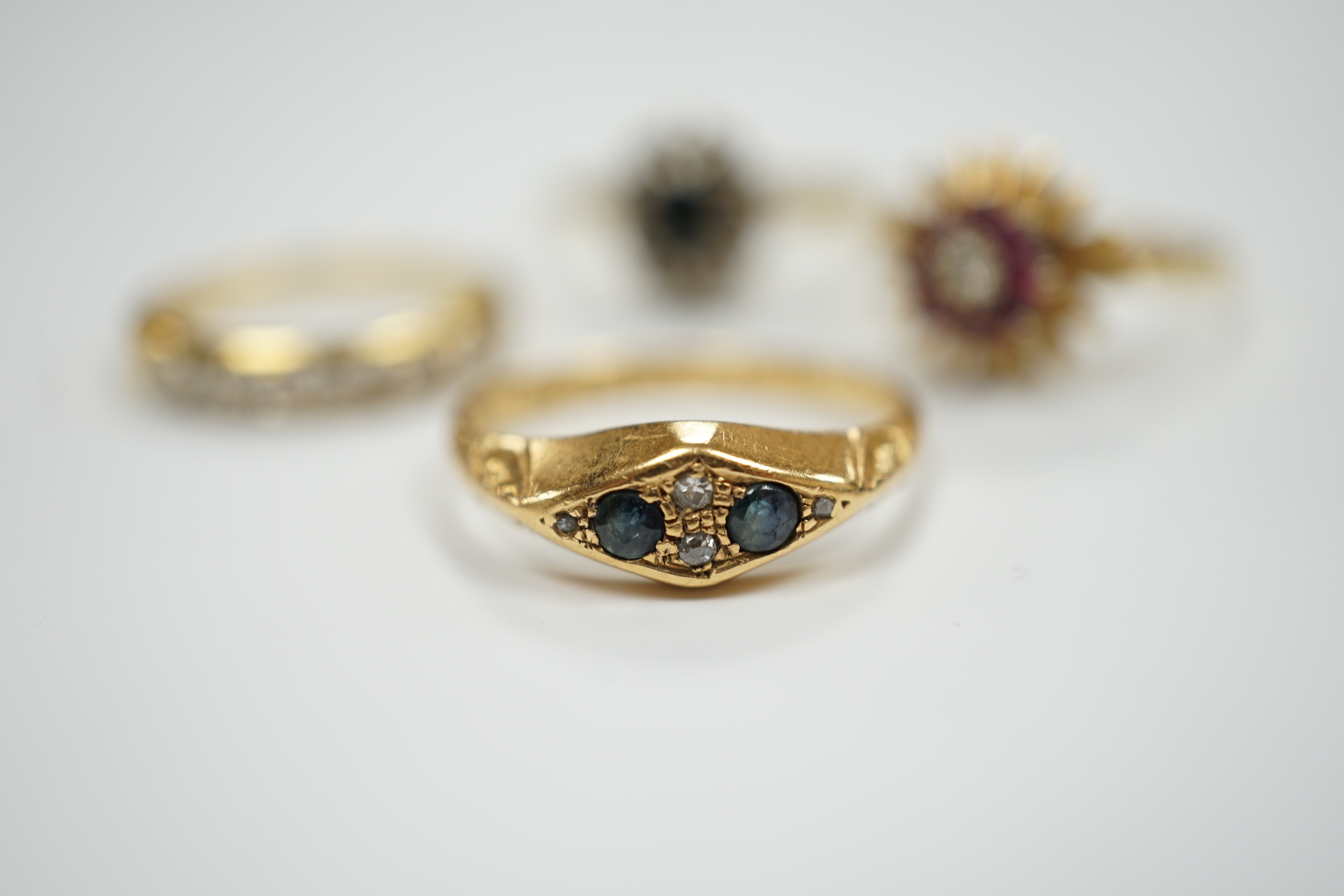 Four assorted Edwardian and later 18ct and gem set rings, including sapphire and diamond chip, size O, gross weight 12.1 grams.